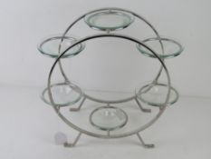 A chrome and glass candle stand 34cm high.