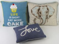 Three throw cushions in blue hues.