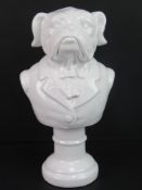 A white ceramic bust having suited male shoulders with bulldog head upon.