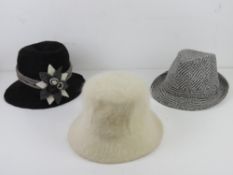 Two woollen hats together with a Trilby.