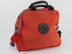 An orange canvas bag by Kipling with key