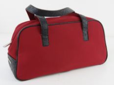 A red fabric and black leather bag by Fi