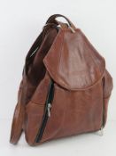A vintage brown leather rucksack marked