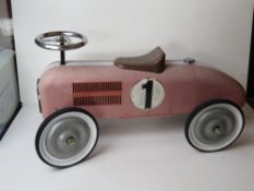 A metal children's ride-on racing car, one bracket a/f, approx 70cm in length.