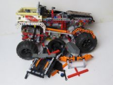 Lego Technic; a part-built 4 x 4 vehicle, inc four tyres and various parts.