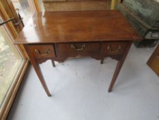 A Low Boy raised over square legs having central drawer with twin box drawers flanking,