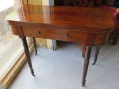 A fold over games table opening to reveal green baize top all raised over graduated turned legs