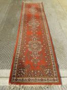 An orange ground Persian runner measuring approx 320 x 80cm.