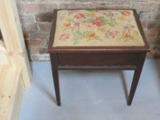 A piano stool with embroidered seat, lid lifting to reveal music compartment within,