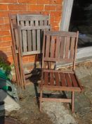 A set of three folding wooden garden chairs.