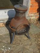 A short chiminea with lid, door slightly a/f.