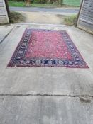 A woollen rug in pinks and blues, measuring approx 360 x 252cm.