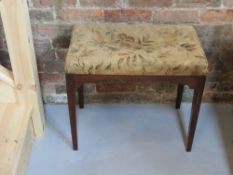 A piano stool having tapestry seat, measuring approx 58.5 x 36 x 32cm.