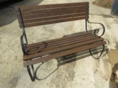 An early 20th century garden bench having metal scroll type ends, measuring approx 117cm wide.