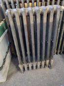 A refurbished cast iron Victorian column radiator having eight fins and integral feet,