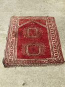 A woollen rug in red, measuring approx 114 x 87cm.