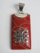 A silver mounted pendant in red with filigree design upon, stamped 925, 5.3cm inc bale.