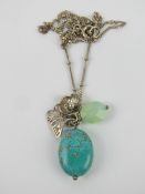 A silver and turquoise bead pendant having butterfly upon, on silver chain.