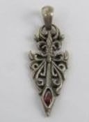 A white metal and red stone pendant of gothic form, stamped 925 and measuring 5cm in length.