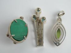 A white metal and marcasite pendant together with three other pendants stamped 925. Four items.