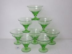 A set of eight green glass champagne saucers.