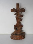 A black forest type carved wooden decorative ecclesiastical shrine having crucifix with vine leaves