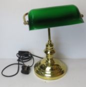 A brass banker's lamp having shaped green glass shade.