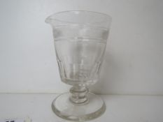 A single clear glass footed pouring cup having spout to one side, 15.5cm high.