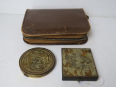 Two vintage compacts, one opening to reveal pressed powder, lipstick and cigarette holders.