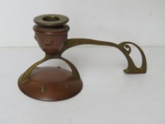 A single copper and brass candlestick of Art Nouveau design measuring approx 22cm wide.