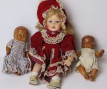 Two plasticised mid century dolls together with a late 20th century porcelain doll. Three items.