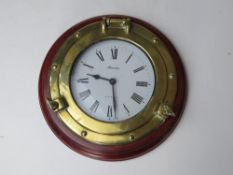 A porthole maritime themed wall clock having quartz movement and brass 'porthole',