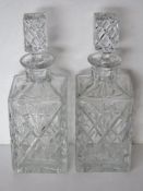A pair of cut crystal square shaped decanters standing approx 24.5cm high.