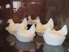 Four assorted opaque milk glass egg baskets in the form of chickens together with a blue and white