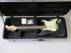 An electric guitar in a TGI case with tuner, etc.