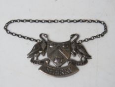 A HM silver sherry decanter label having pair of birds and triple barrel crest upon having banner