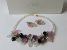 A floral contemporary beaded necklace with matching earrings in Daisy Chain of Cambridge England