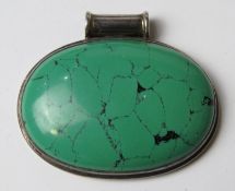 A large green hardstone pendant in white metal mount, stamped 925, approx 6cm wide.