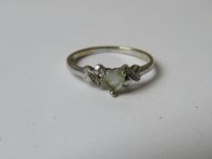 A 9ct white gold ring having heart shaped white stone to centre, diamond chip to each shoulder,