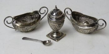 A pair of Walker & Hall HM silver salts having repoussé floral design upon, one handle a/f,