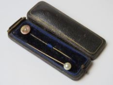 A 15ct gold cravat pin having split pearl to centre, together with another cravat pin,