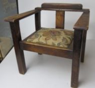 A early 20thC wooden child's armchair having fabric seat.