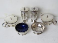 A silver plated cruet set comprising pair of pepperettes, pair of salts (one liner deficient),