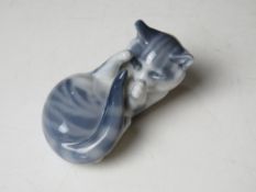A Royal Copenhagen blue and white kitten playing with its tail, Nbr 727, approx 10cm in length.