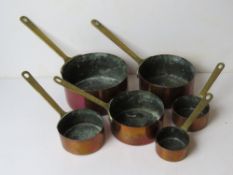 A set of six graduated copper and brass saucepans, largest 16cm dia.