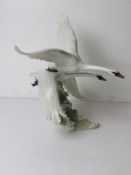 A 1980s large porcelain sculpture of German geese in flight over a cresting wave,