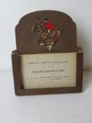 A 1930's easel hunting meet card stand having pierced and coloured mounted huntsman in full cry