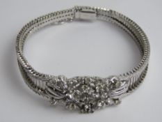 A white stone floral design bracelet, indistinct marks.