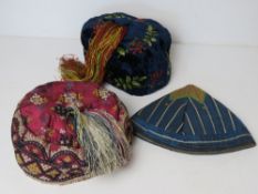 Three silken and velvet caps of Oriental style, two having tassels upon.