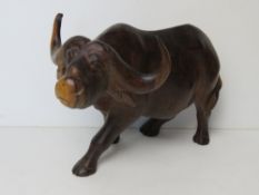 A large hand carved wooden figurine of a water buffalo approx 30cm in length.